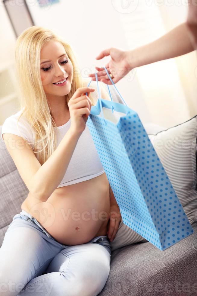 Happy pregnant woman getting presents at baby showe photo