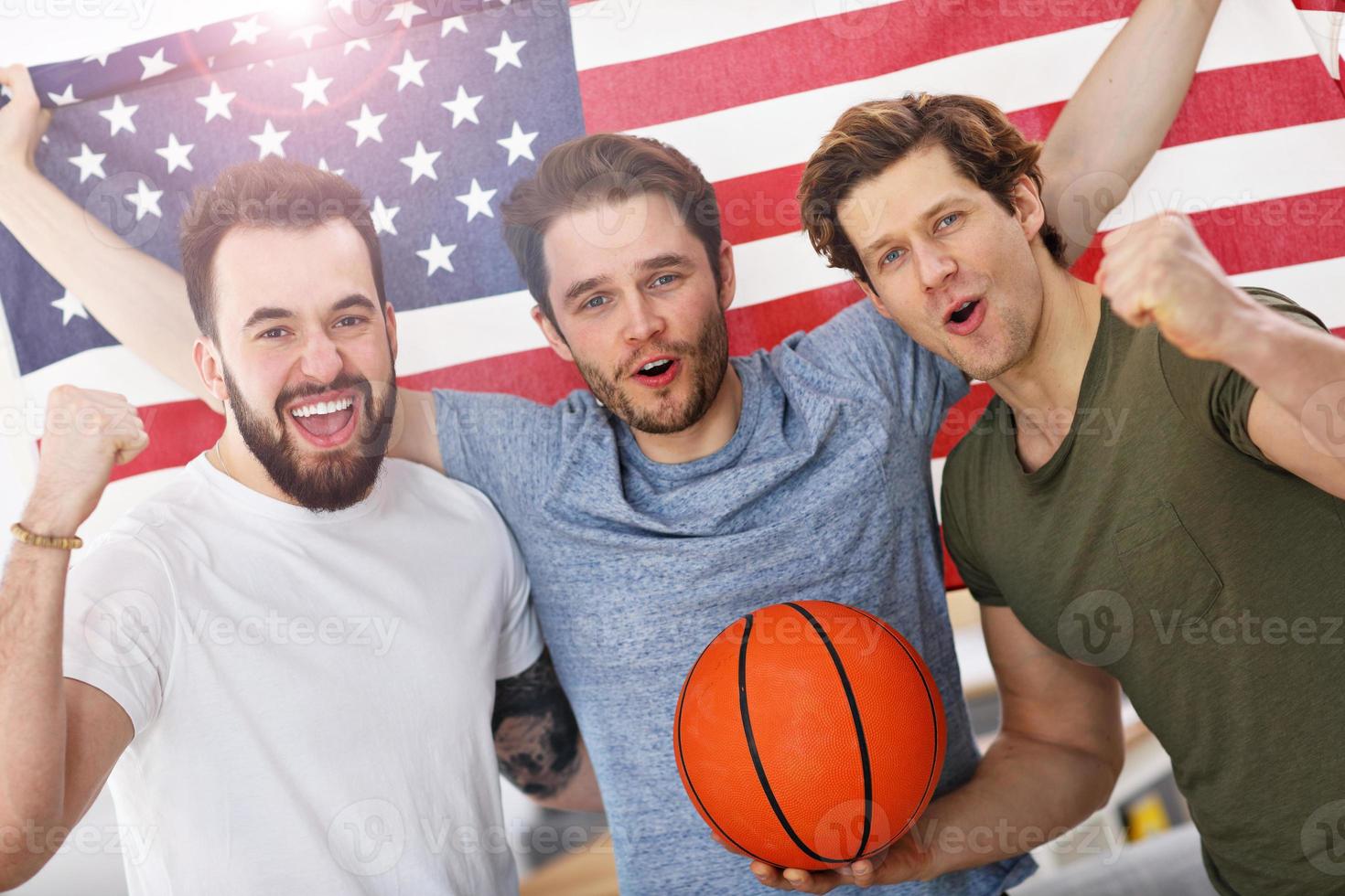 Happy american basketball fans cheering over flag photo