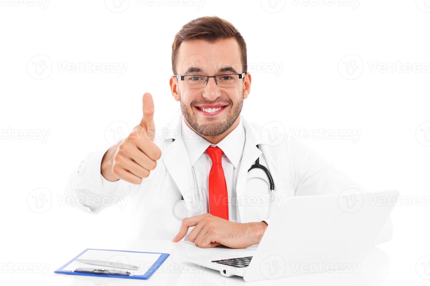 Doctor with laptop and documents showing ok sign photo