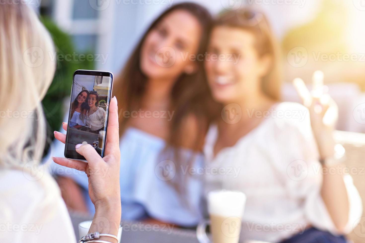 Happy girl friends hanging out in the city in summer photo