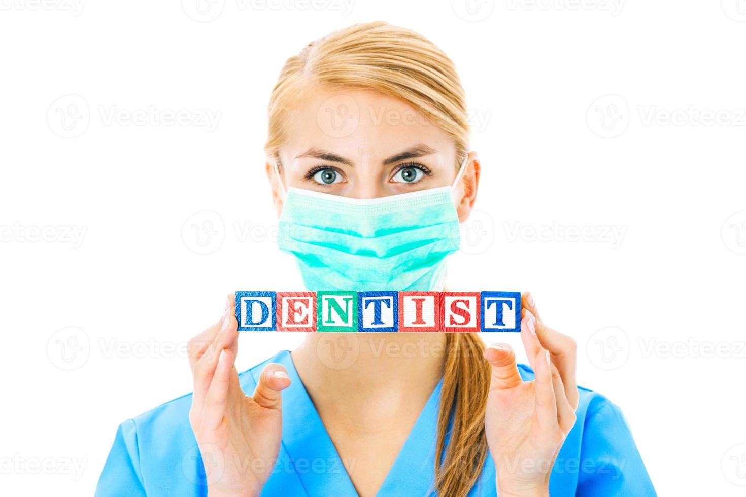 Nurse Holding Blocks Spelling Out Dentist Over White Background photo