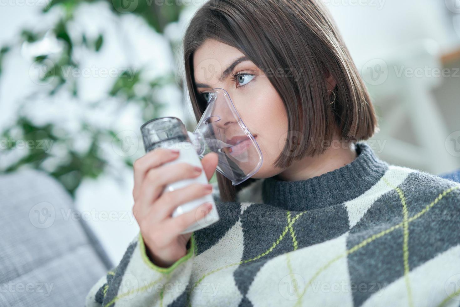 adolescente con un inhalador en la sala de estar foto