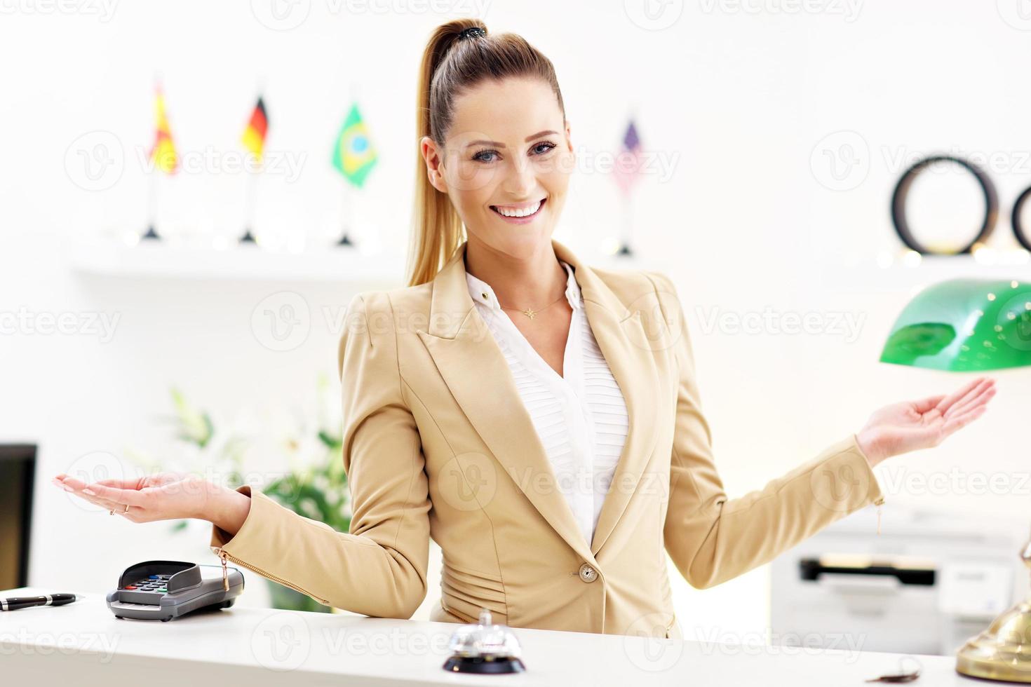 Happy receptionist working in hotel photo