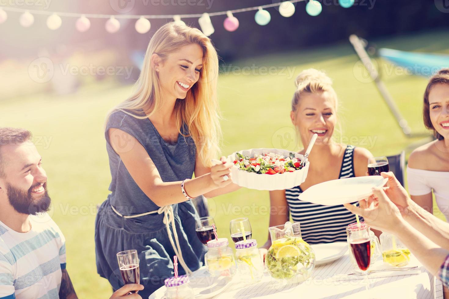 amigos que tienen una fiesta de barbacoa en el patio trasero foto