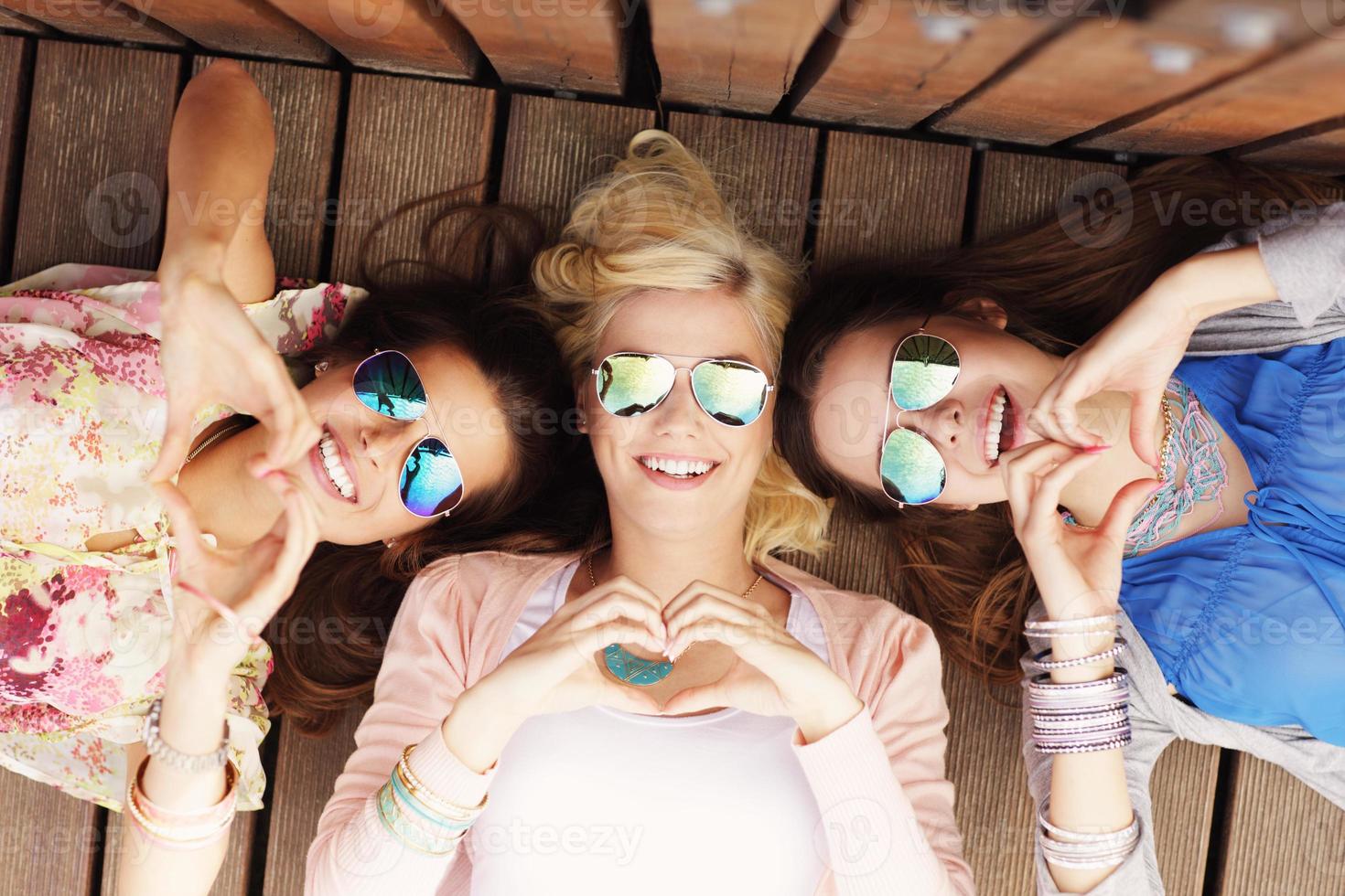 Group of happy friends showing hearts photo