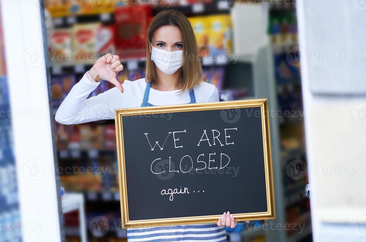 Shop assistant holding announcement board photo