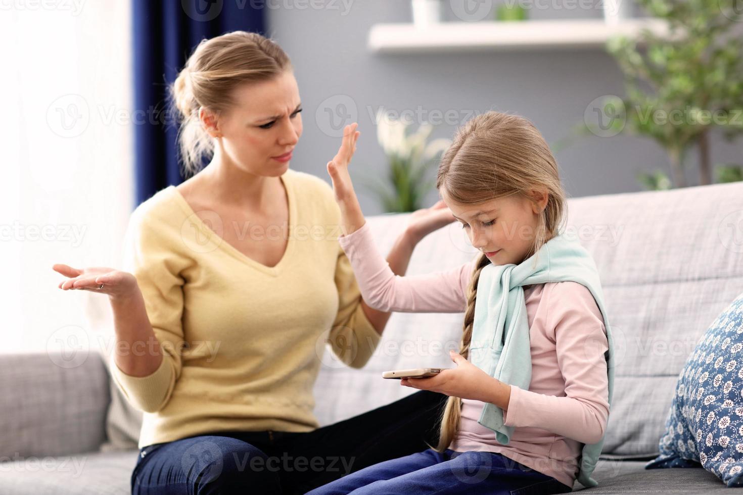 Mother and little daughter having argument at home photo