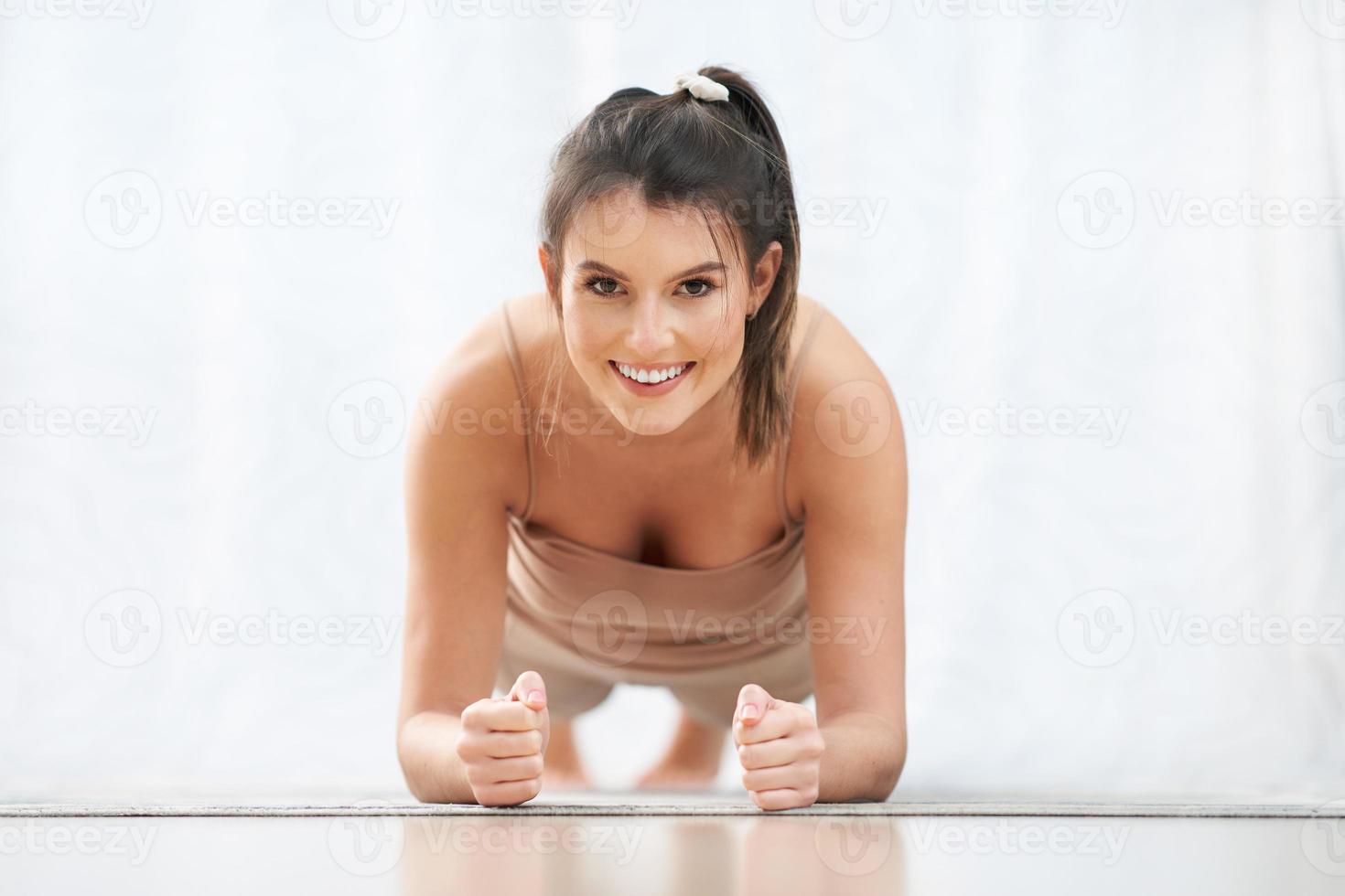 Adult woman practising plank at home photo