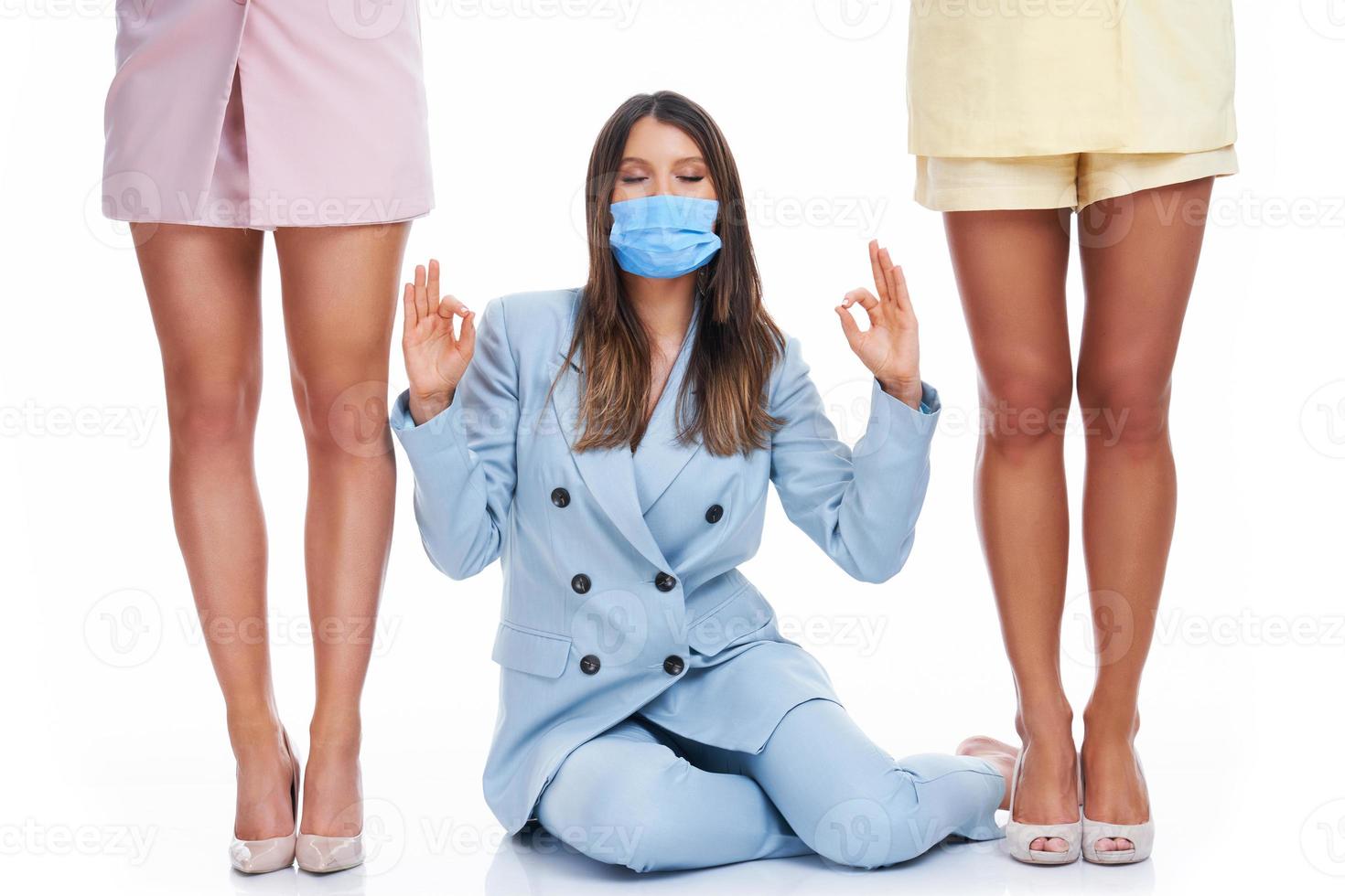 Three women in pastel suits posing over white background photo