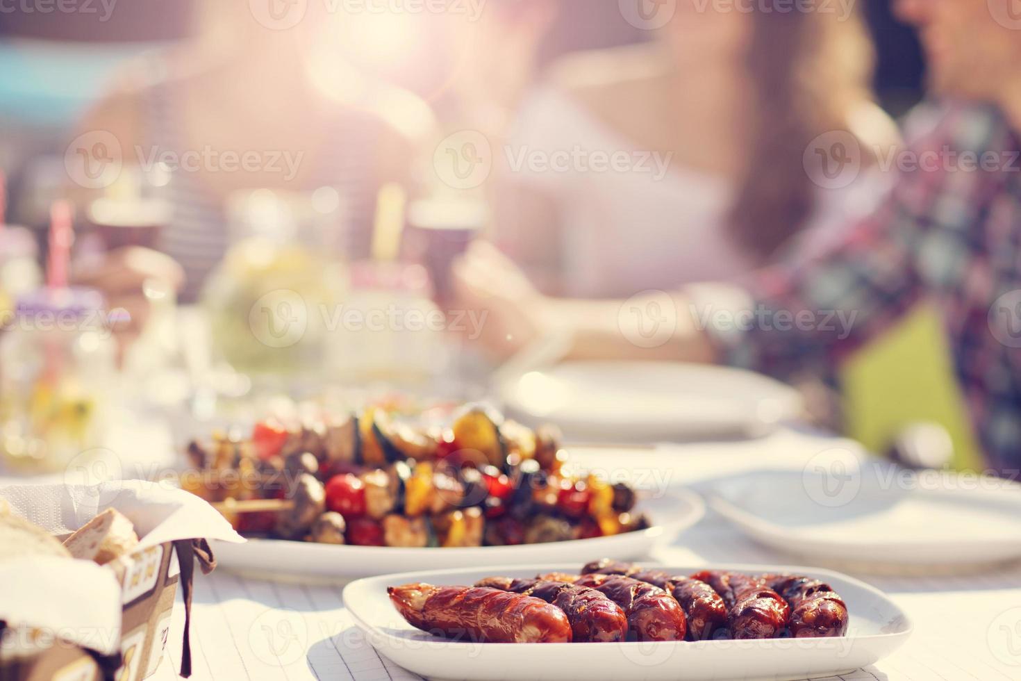 Friends having barbecue party in backyard photo