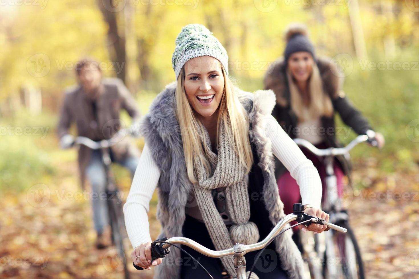 Group of friends on bikes in forest during fall time photo