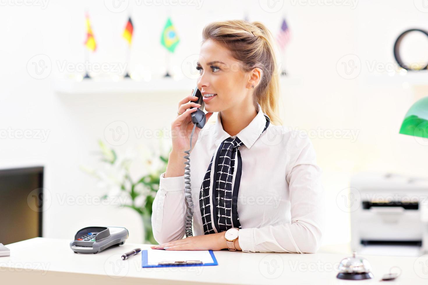 Happy receptionist working in hotel photo
