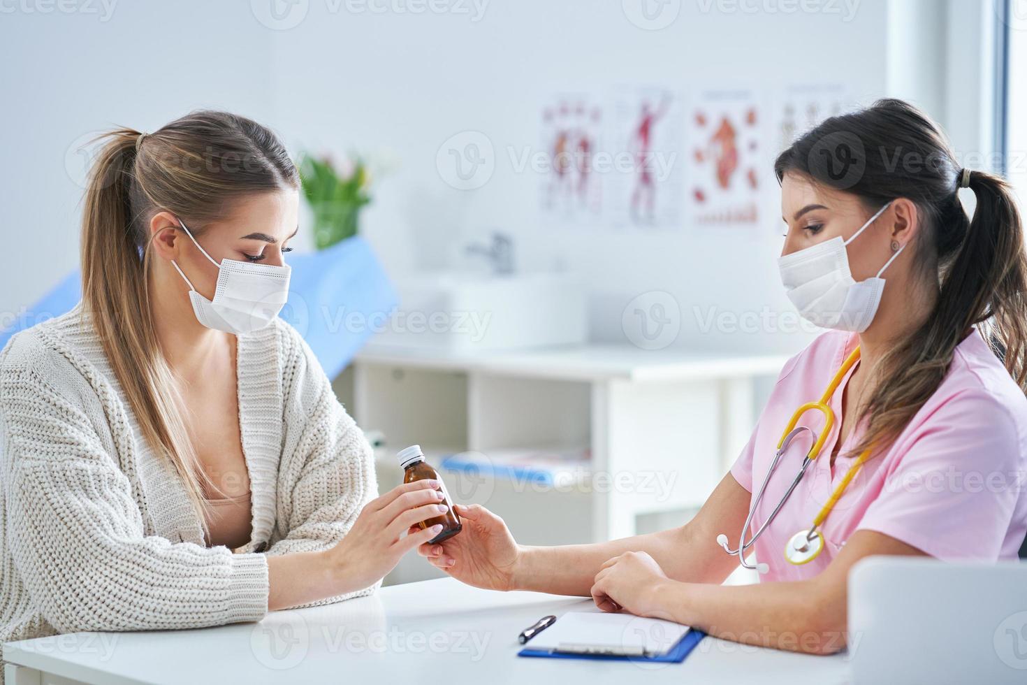 médico enmascarado explicando el diagnóstico a su paciente femenina foto