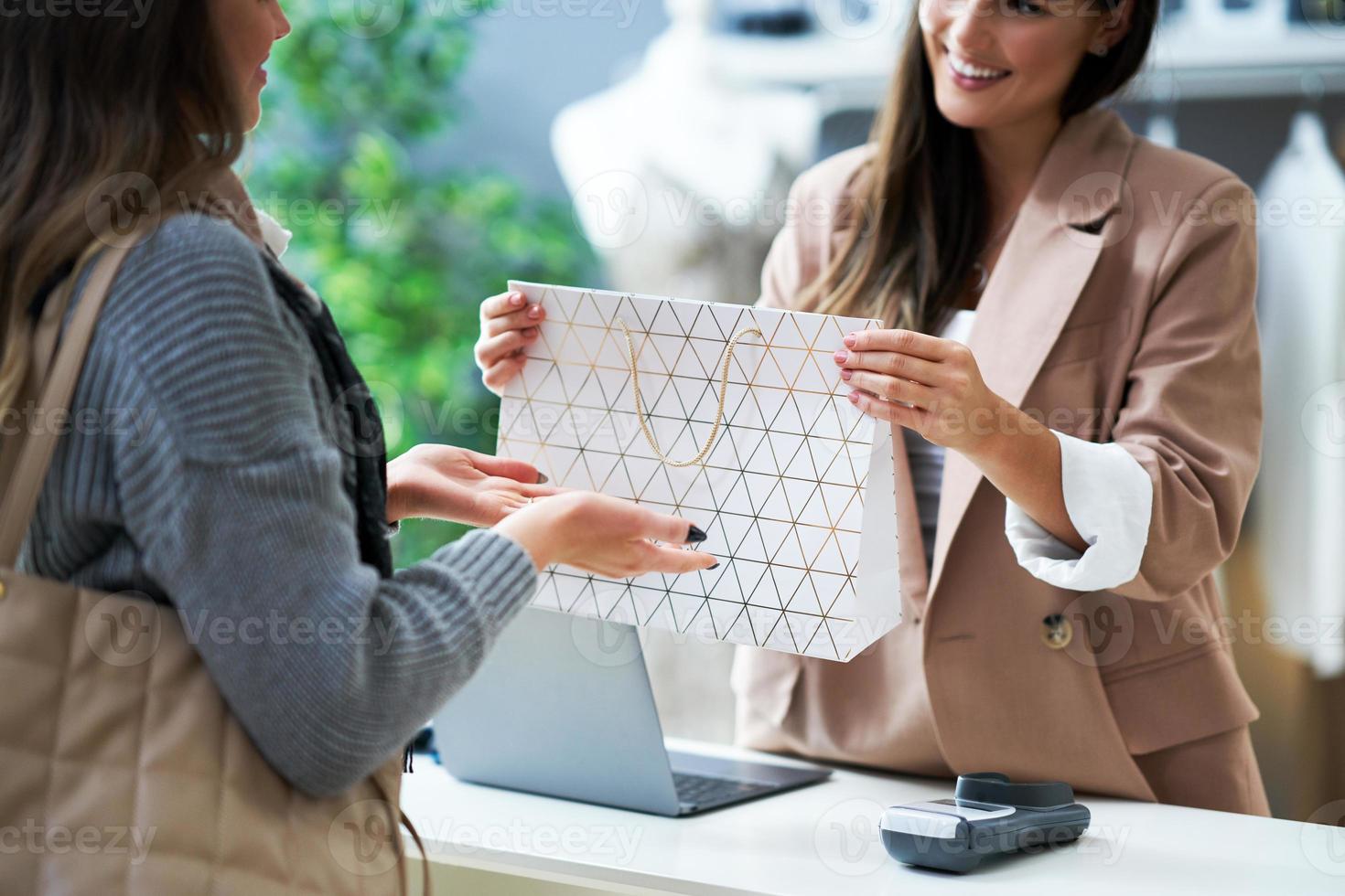 Cashier and buyer in cloth store during transaction photo