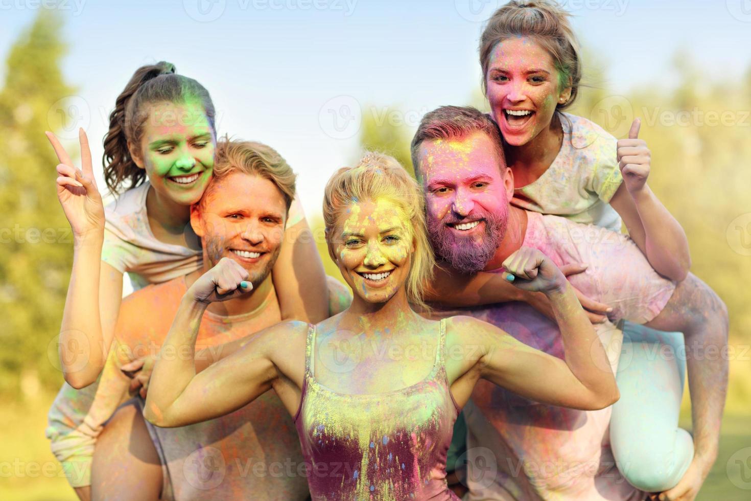 Group of friends having fun at color festival photo