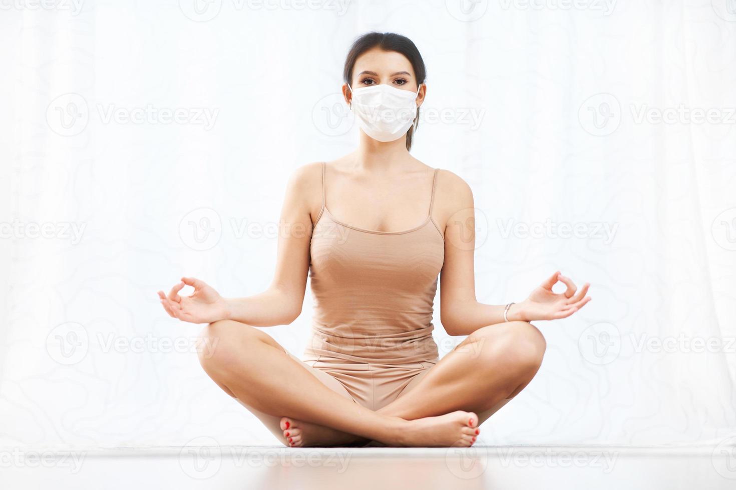 Adult woman working out wearing a mask at home photo