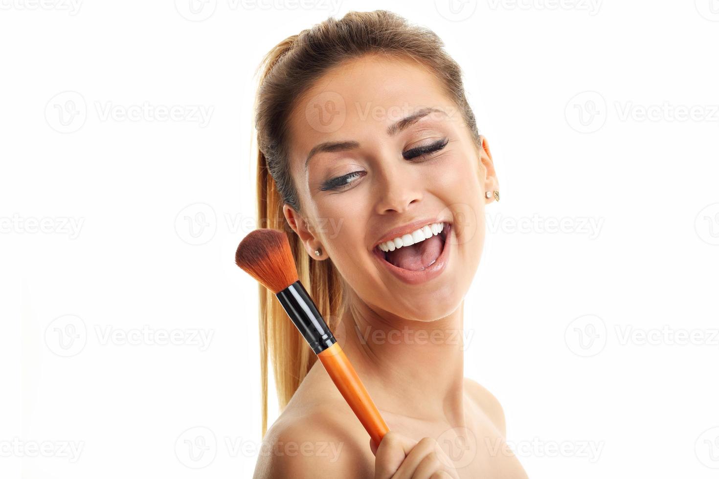 Beauty portrait of adult woman with the makeup brush isolated on white photo