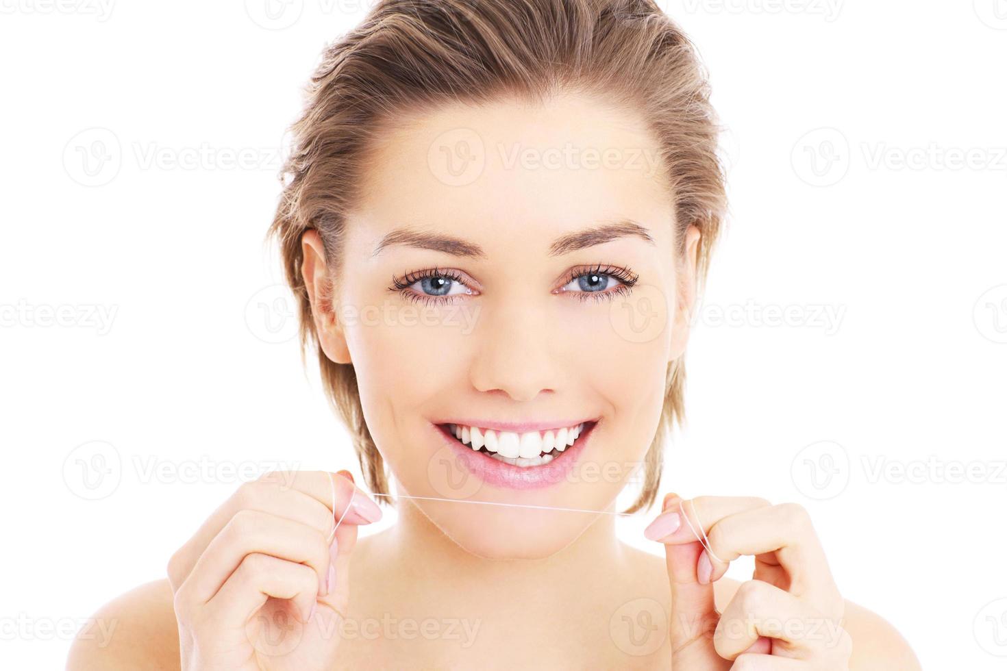 Woman with teeth floss photo