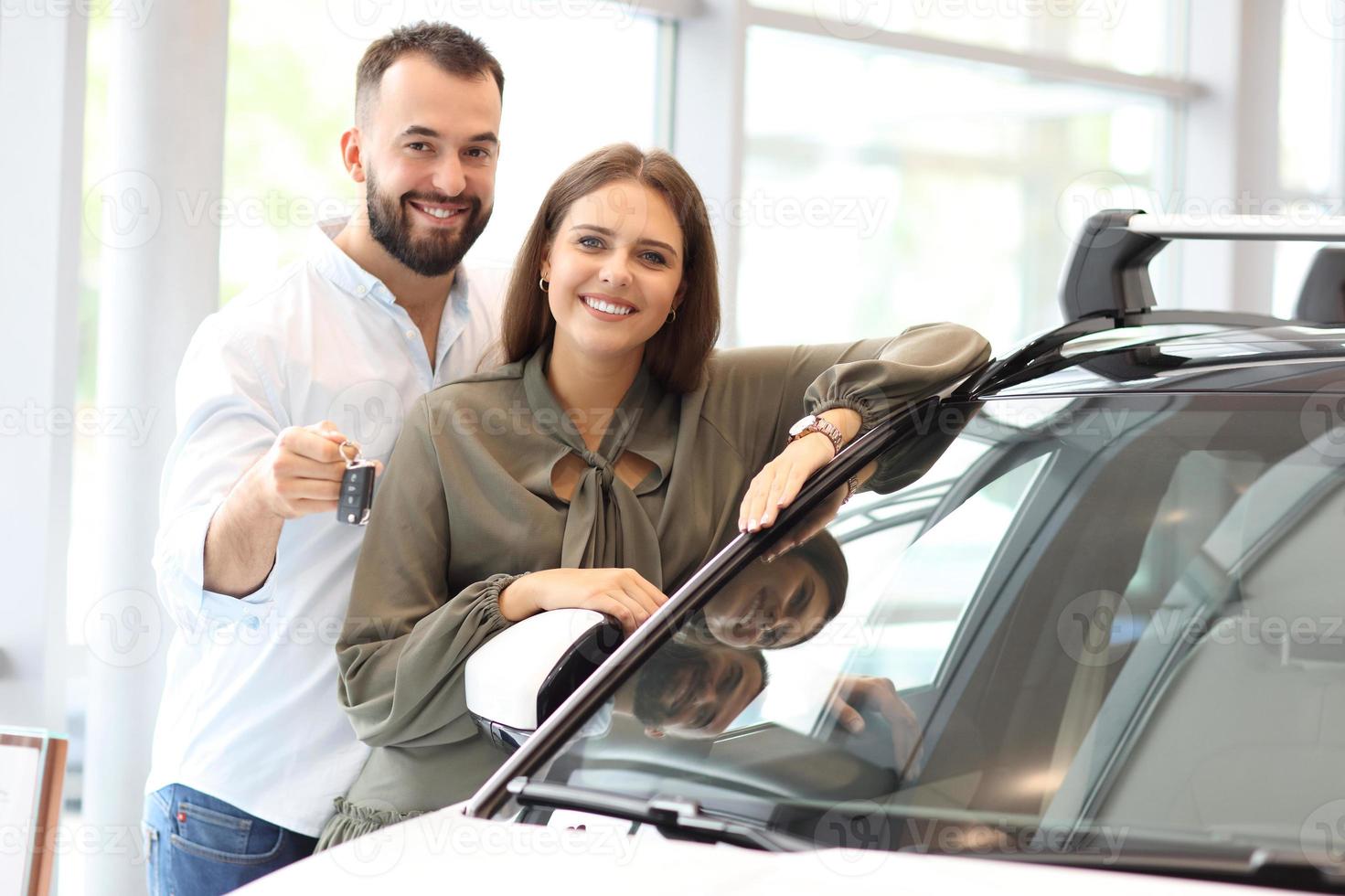 pareja adulta eligiendo auto nuevo en la sala de exposición foto