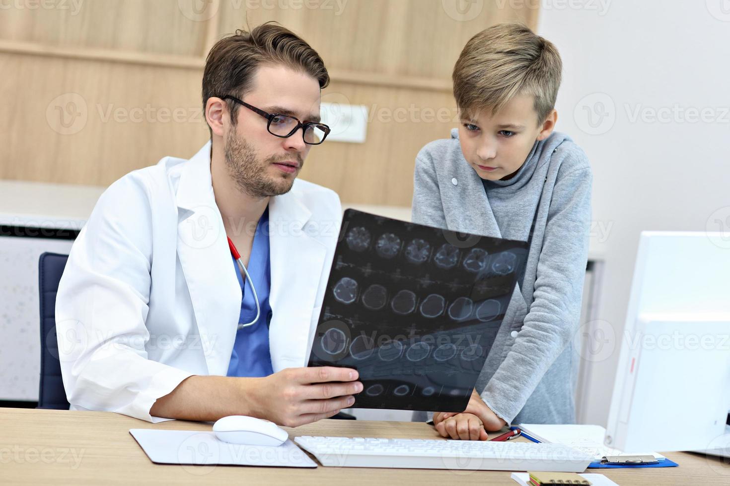 Little boy in clinic having a checkup with pediatrician photo