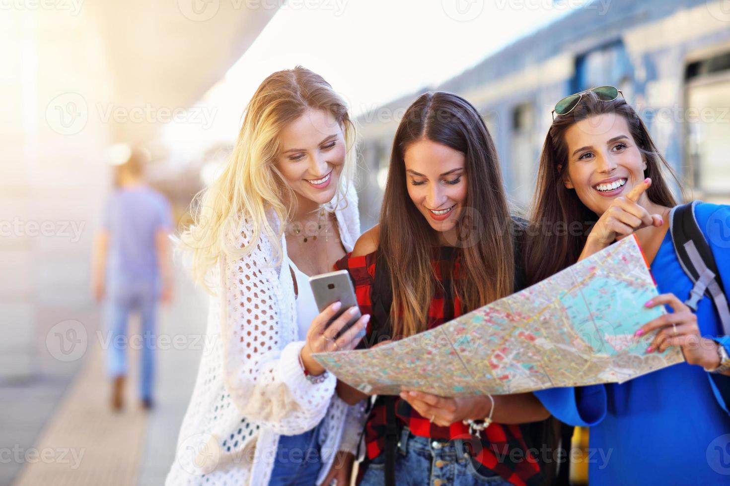 Group of girl friends tourists on railway platform photo