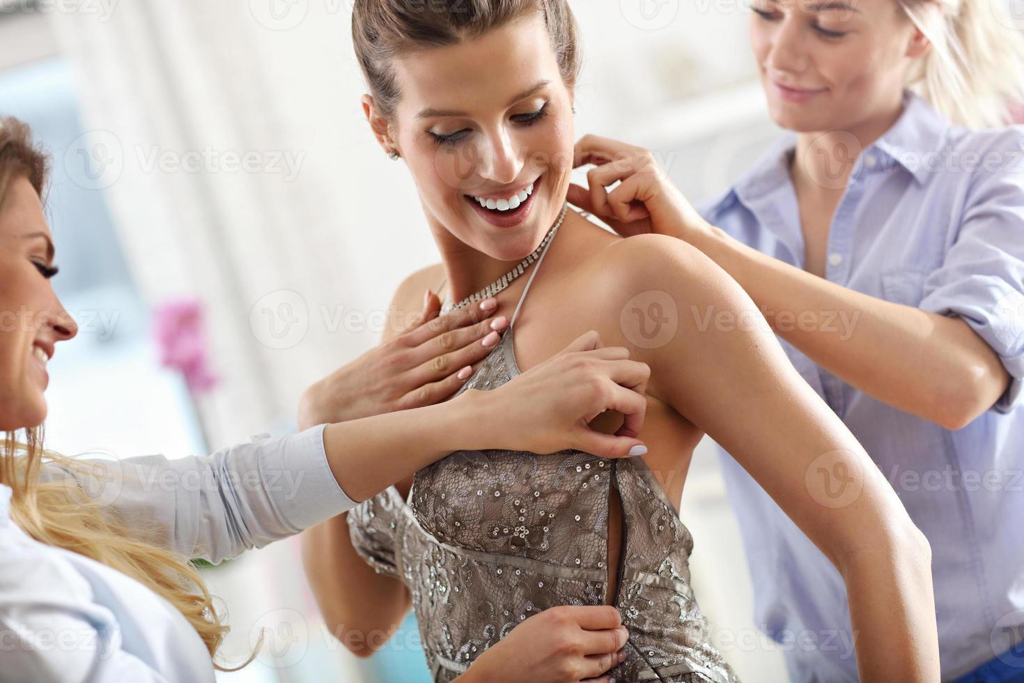 mujer feliz probándose un vestido en la tienda foto