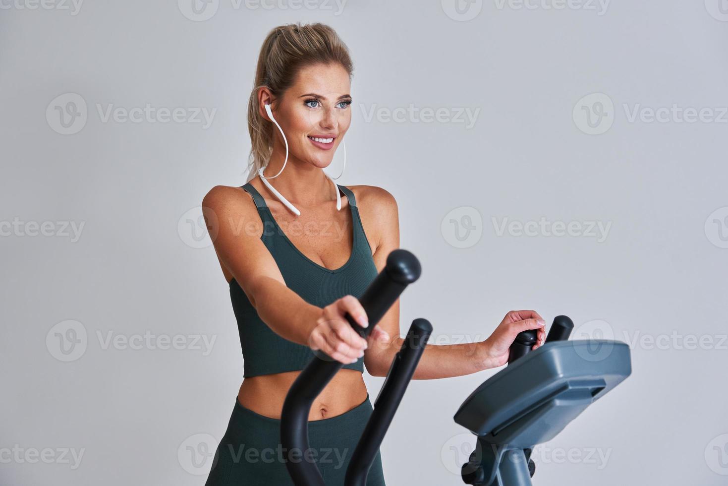 Woman exercising at the gym on crosstrainer photo