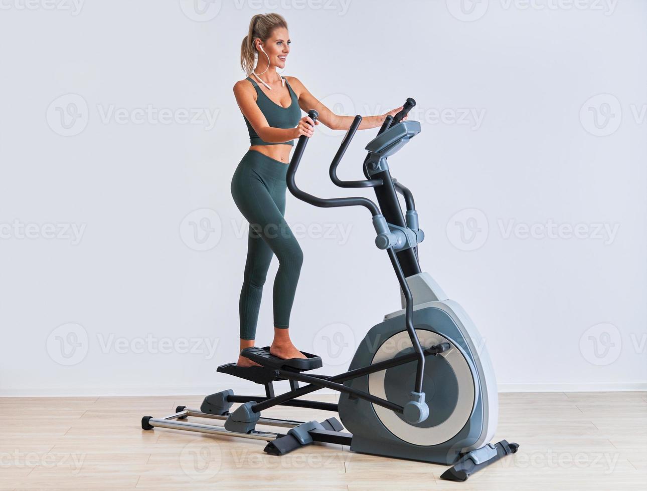 Woman exercising at the gym on crosstrainer photo