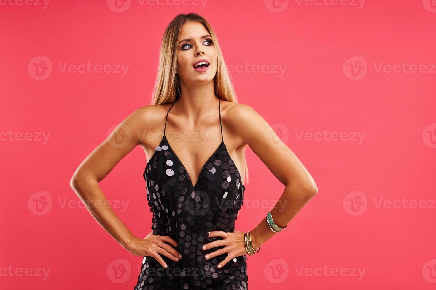 Beautiful adult woman posing over pink background photo