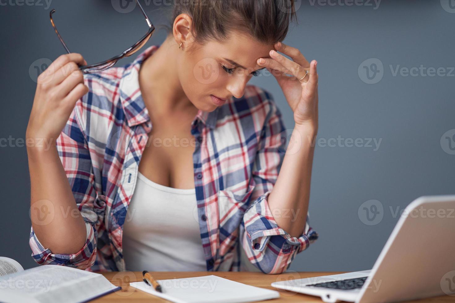 Tired female student learning till late at home photo