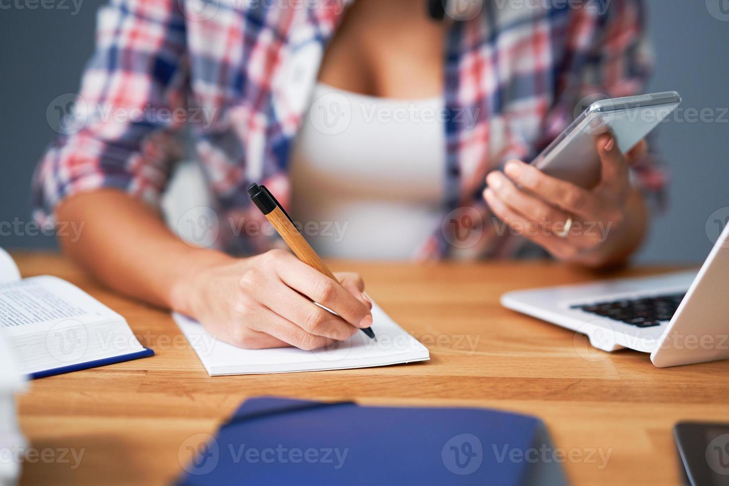 Midsection of female student learning at home photo