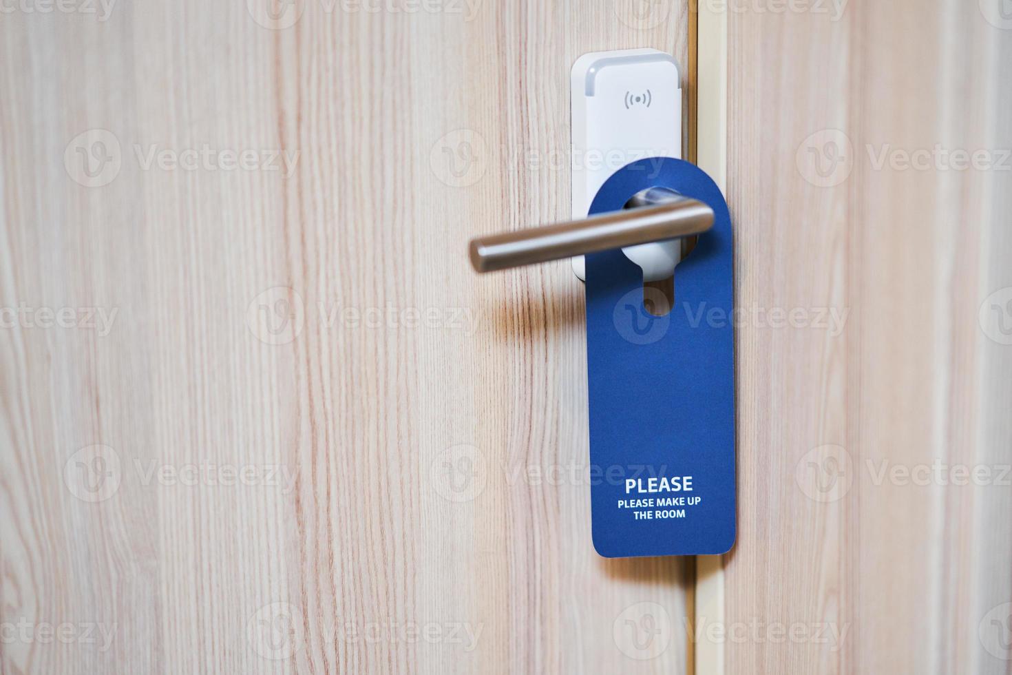 Blue plate hanging on the door handle of a hotel room photo