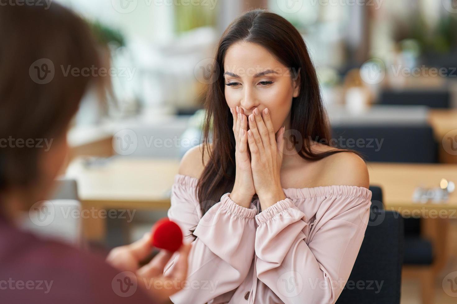 Young man proposing to his girlfriend in a cafe photo