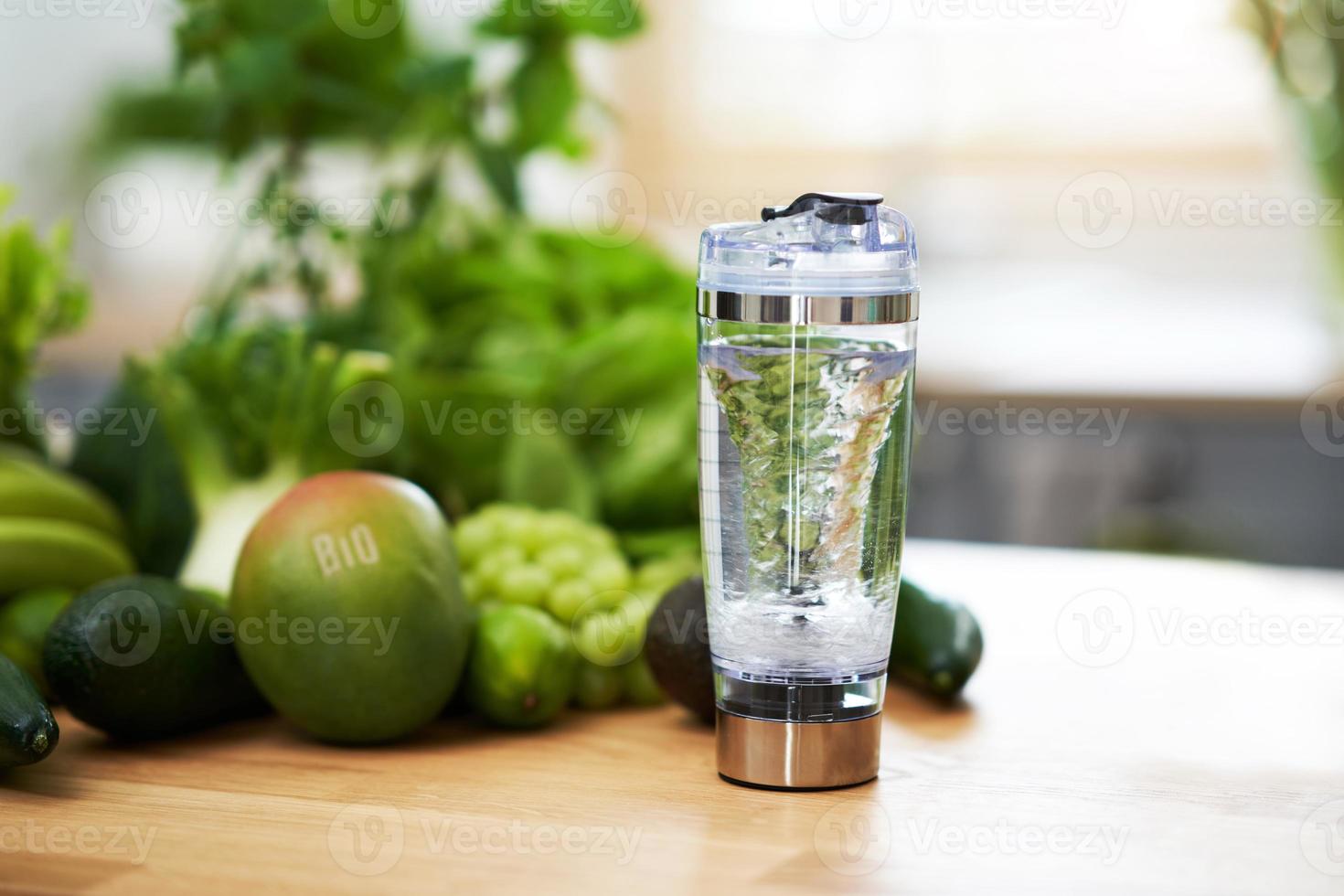 Fresh green fruit and vegetables on wooden counter photo