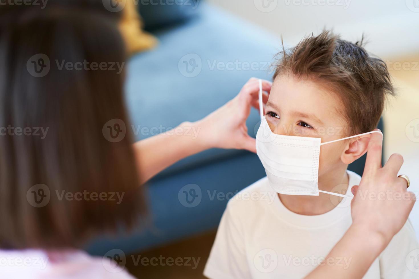 madre e hijo poniéndose máscaras protectoras durante la pandemia del coronavirus foto