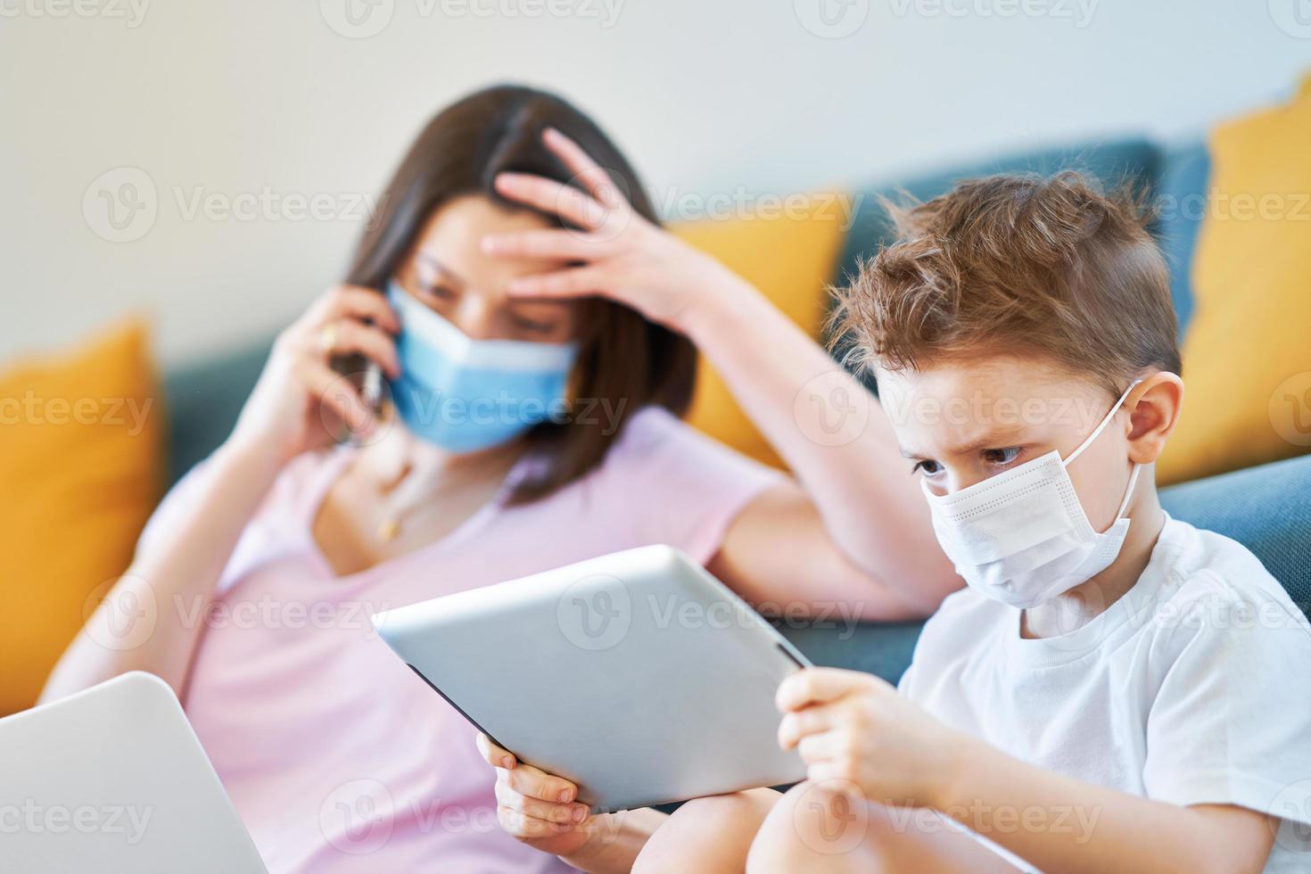 Boy and exhausted mother trying to work at home during coronavirus pandemic photo