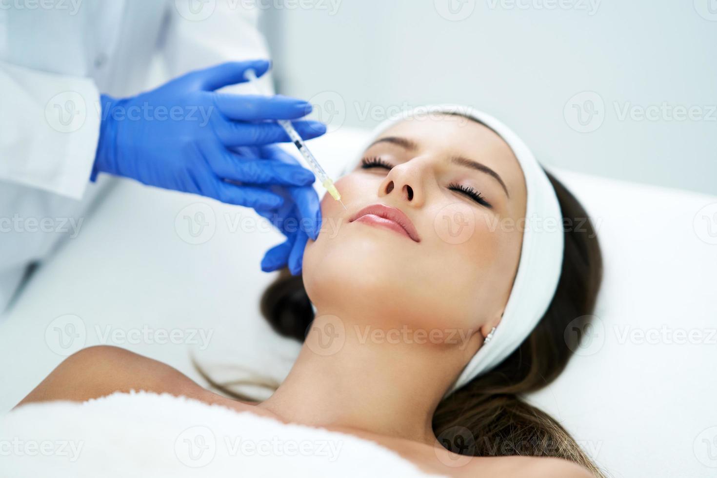 Beautiful young woman getting acid face treatment at beauty salon
