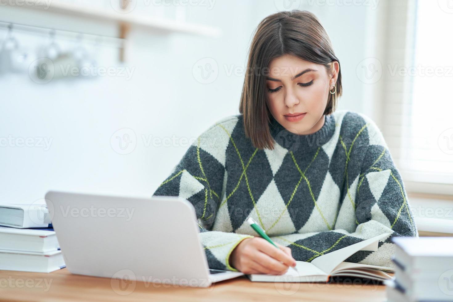 Teenage girl having online classes at home photo