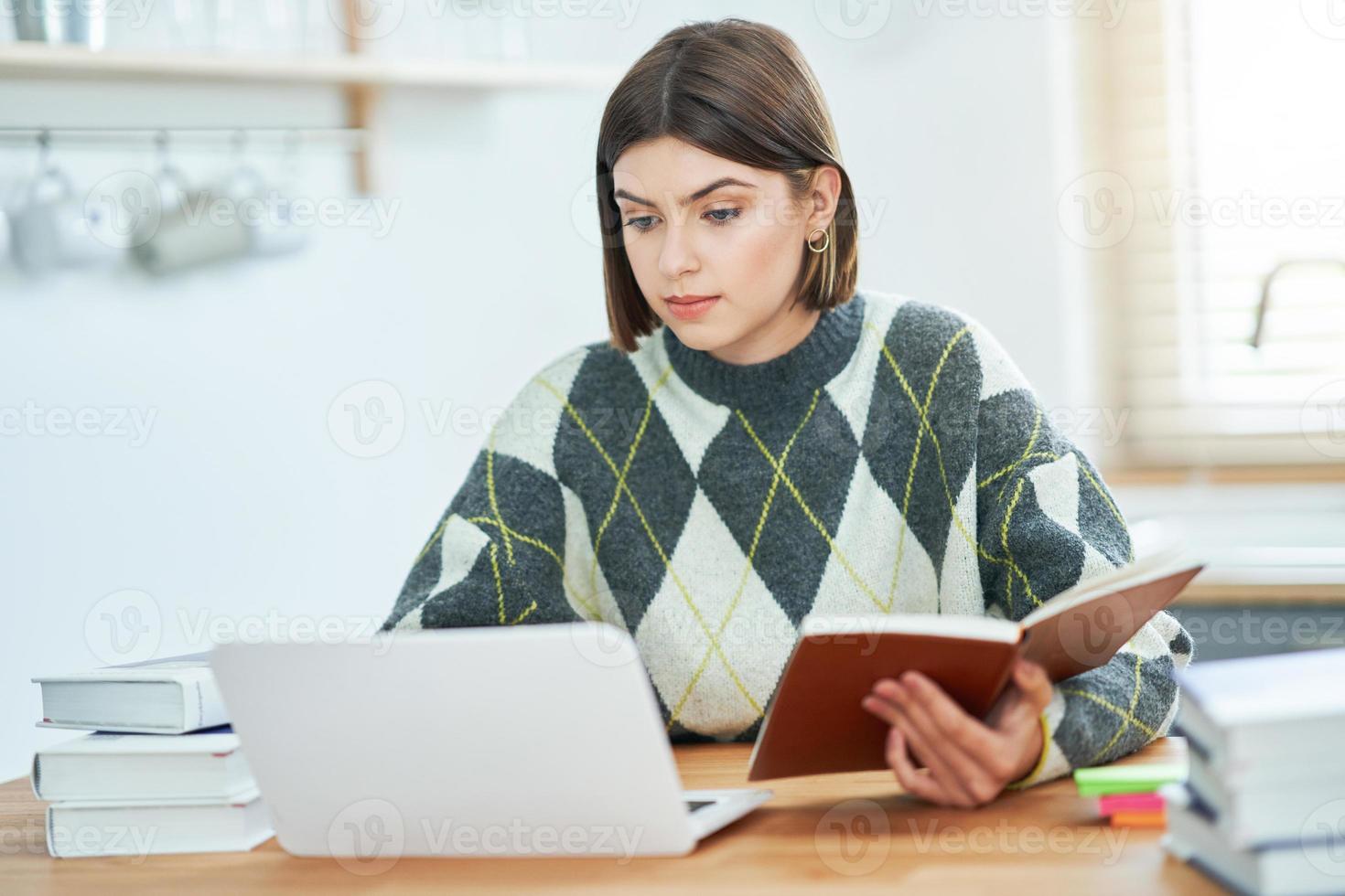 Teenage girl having online classes at home photo