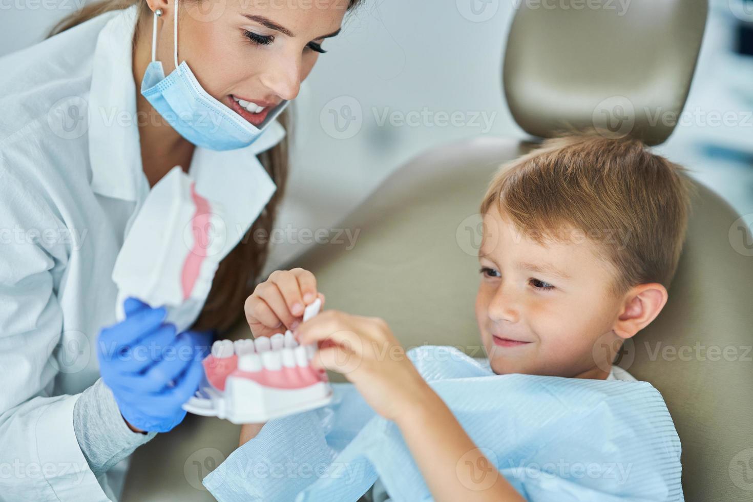 niño pequeño y mujer dentista en la oficina de dentistas foto