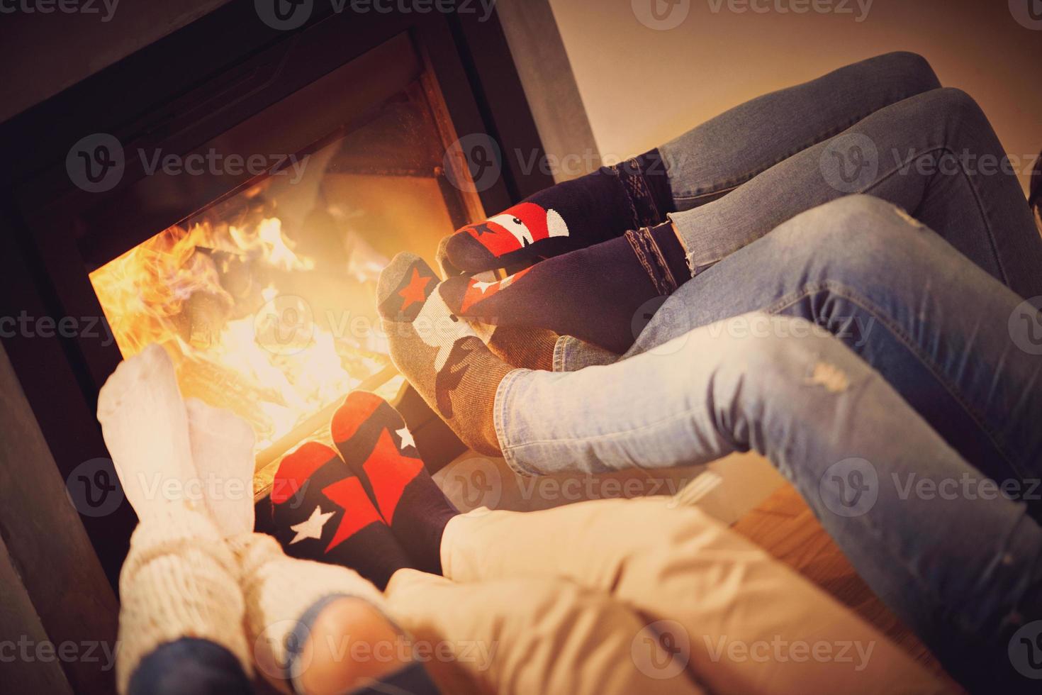 piernas de un grupo de amigos relajándose sobre la chimenea foto