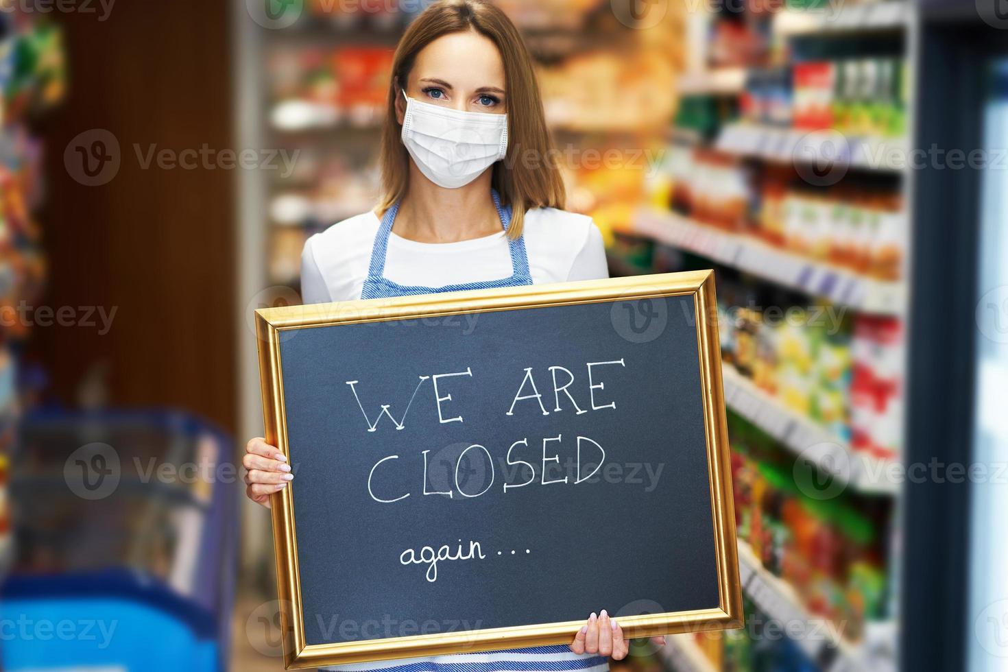 Shop assistant holding announcement board photo