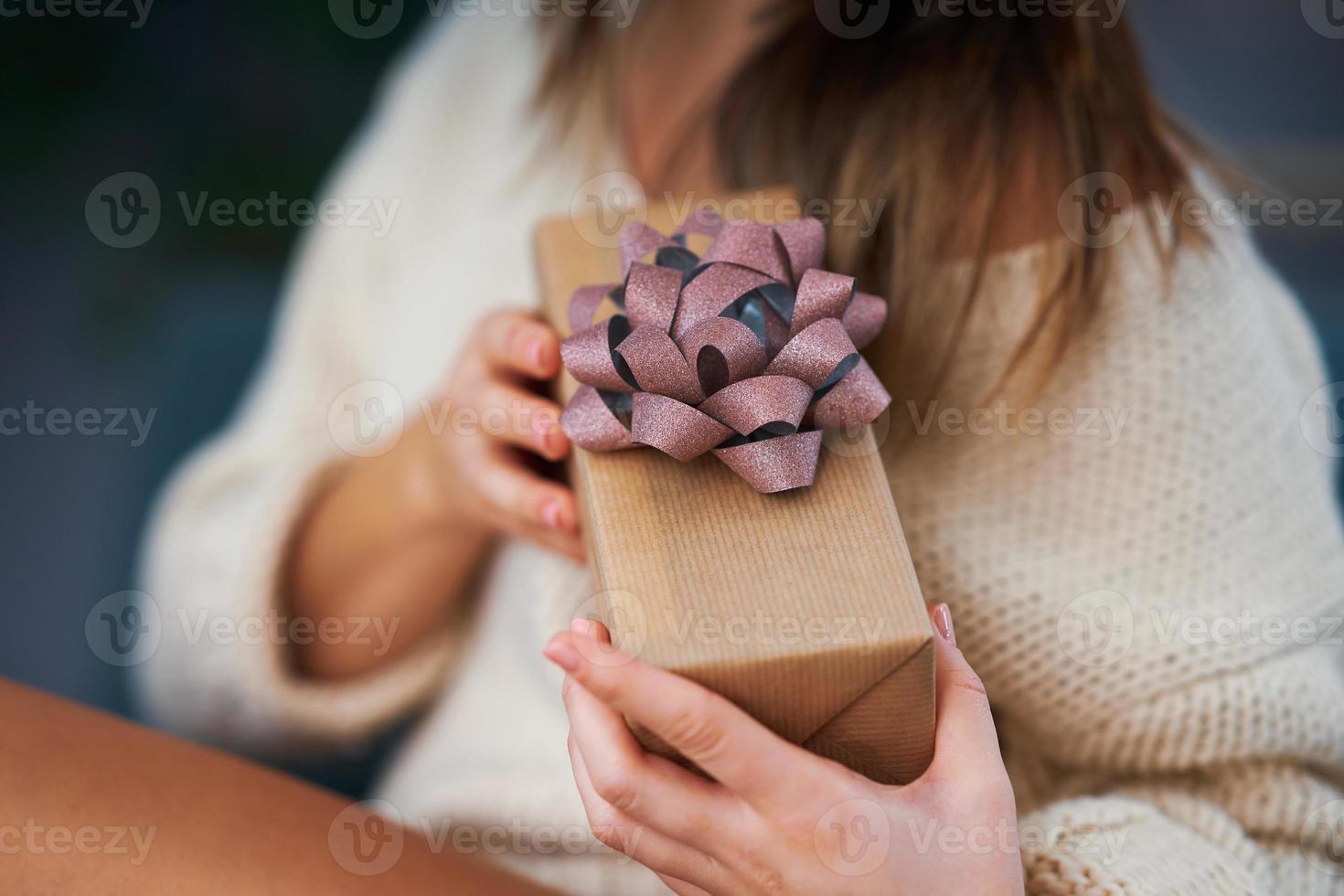 Adult woman with Christmas present at home photo