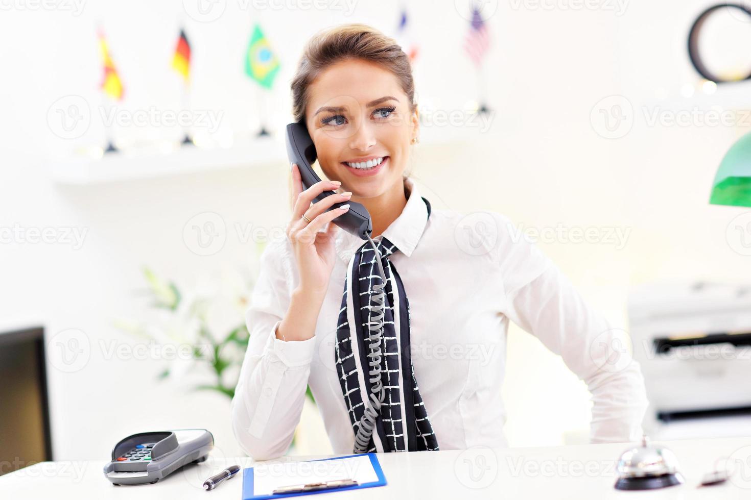 Happy receptionist working in hotel photo