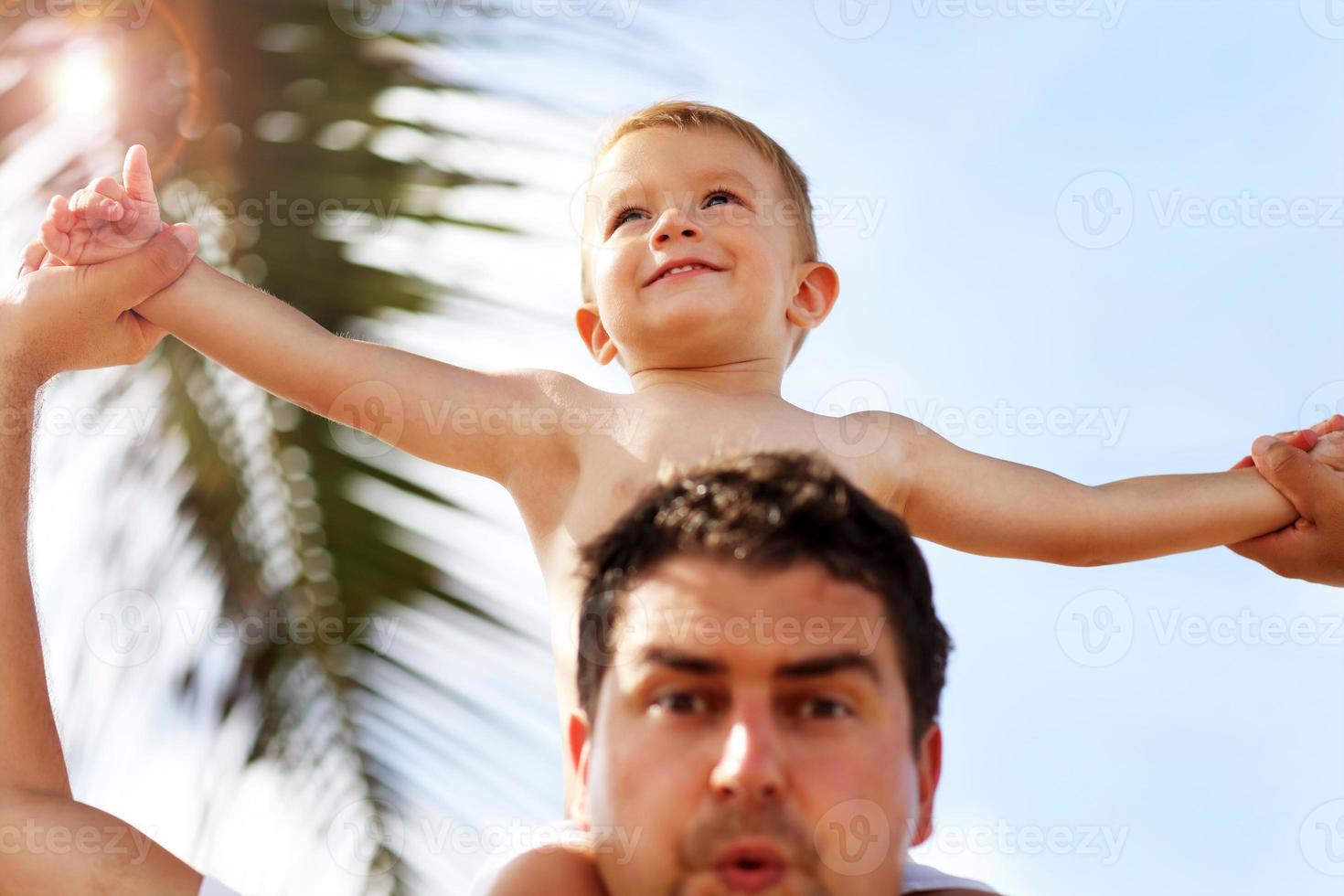 Father having fun on the beach with his little son photo