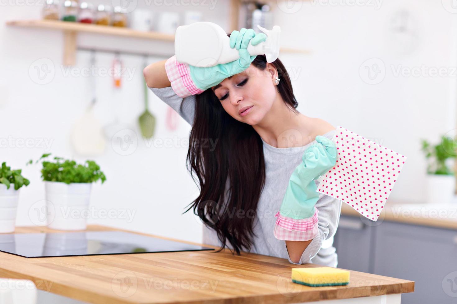 Beautiful young woman cleaning the kitchen photo