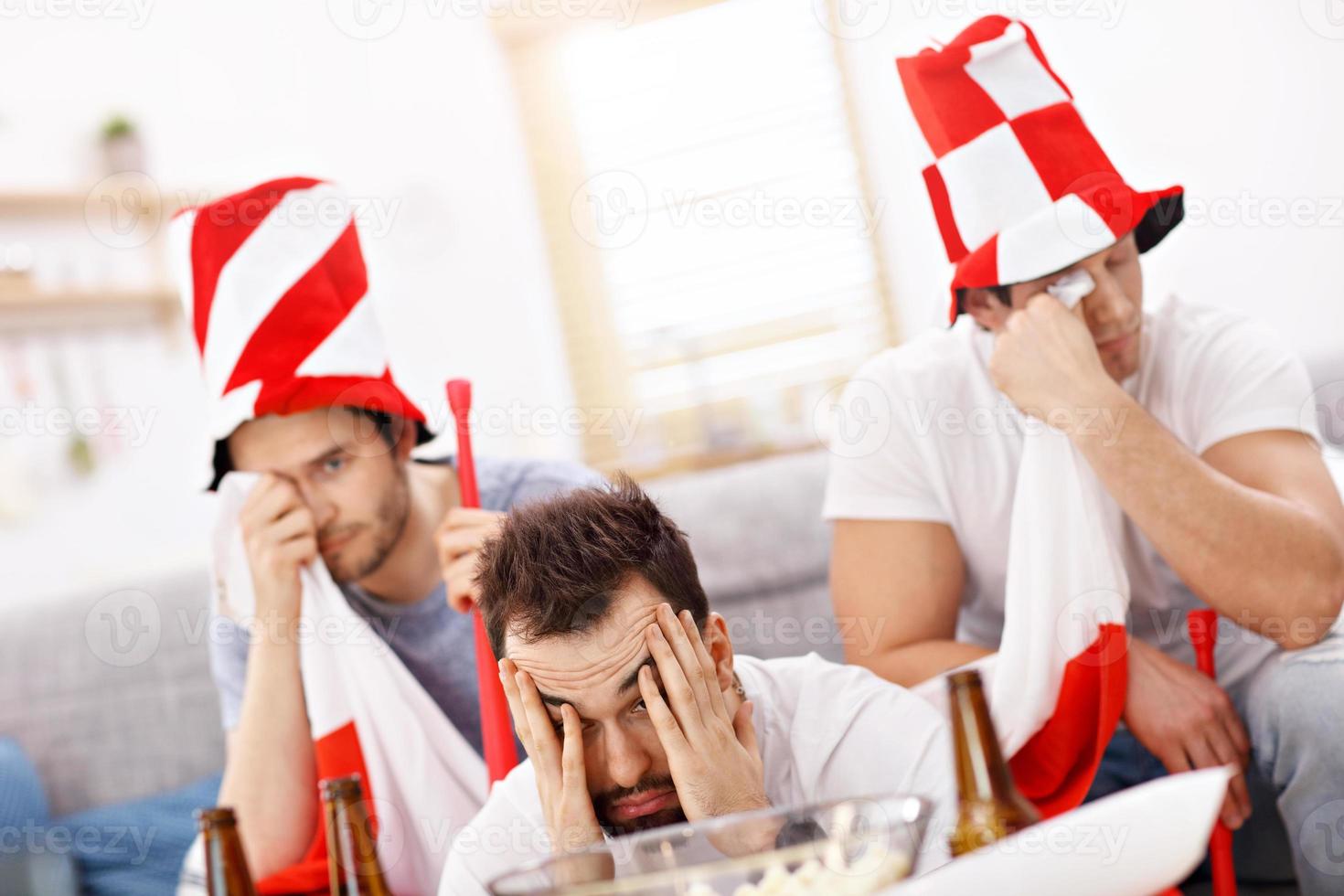 amigos varones felices animando y viendo deportes en la televisión foto