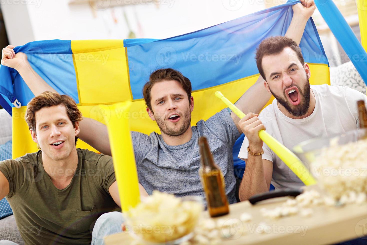 Happy male friends cheering and watching sports on tv 15861364 Stock