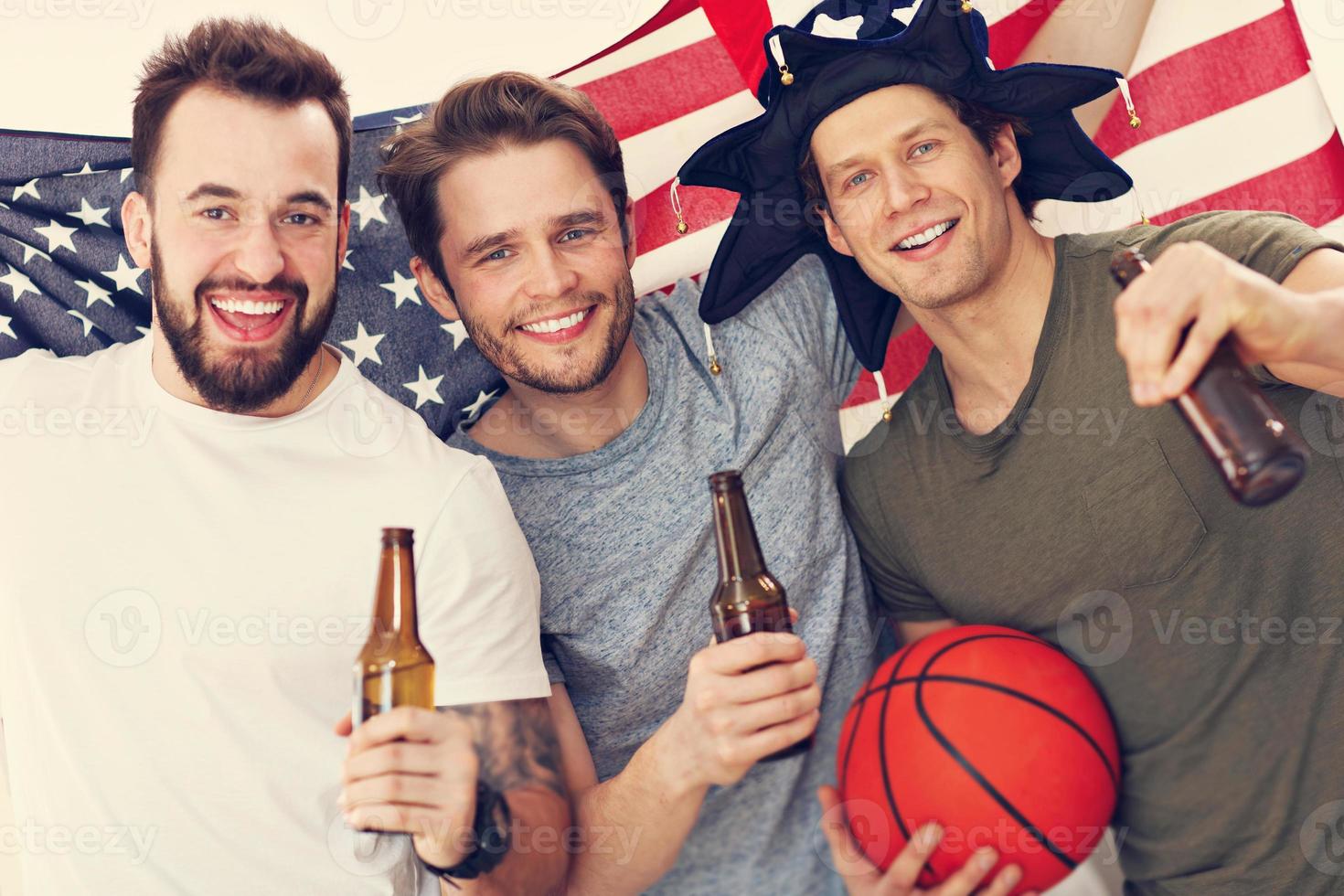 felices fanáticos del baloncesto americano animando la bandera foto