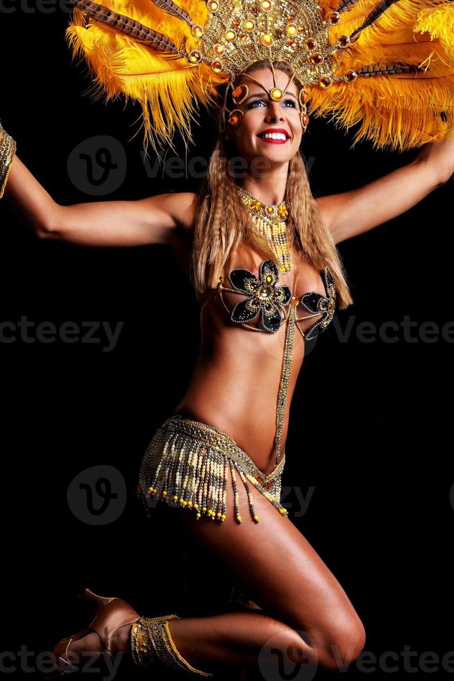 mujer brasileña posando en traje de samba sobre fondo negro foto